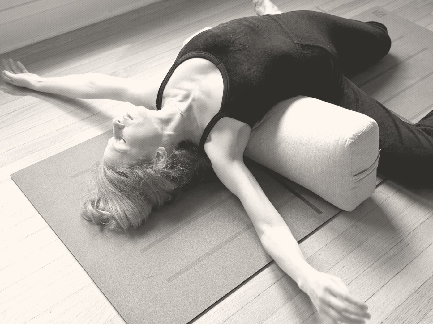 Kathryn Norris resting in a supported yin twist over a bolster