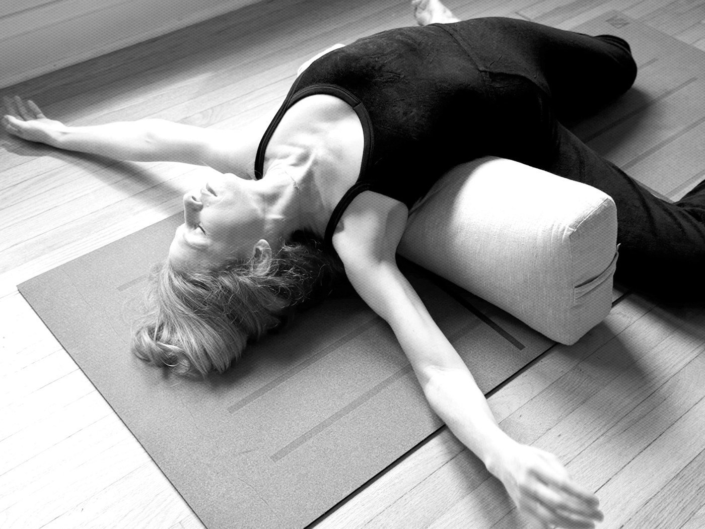 Kathryn Norris resting in a supported yin twist over a bolster