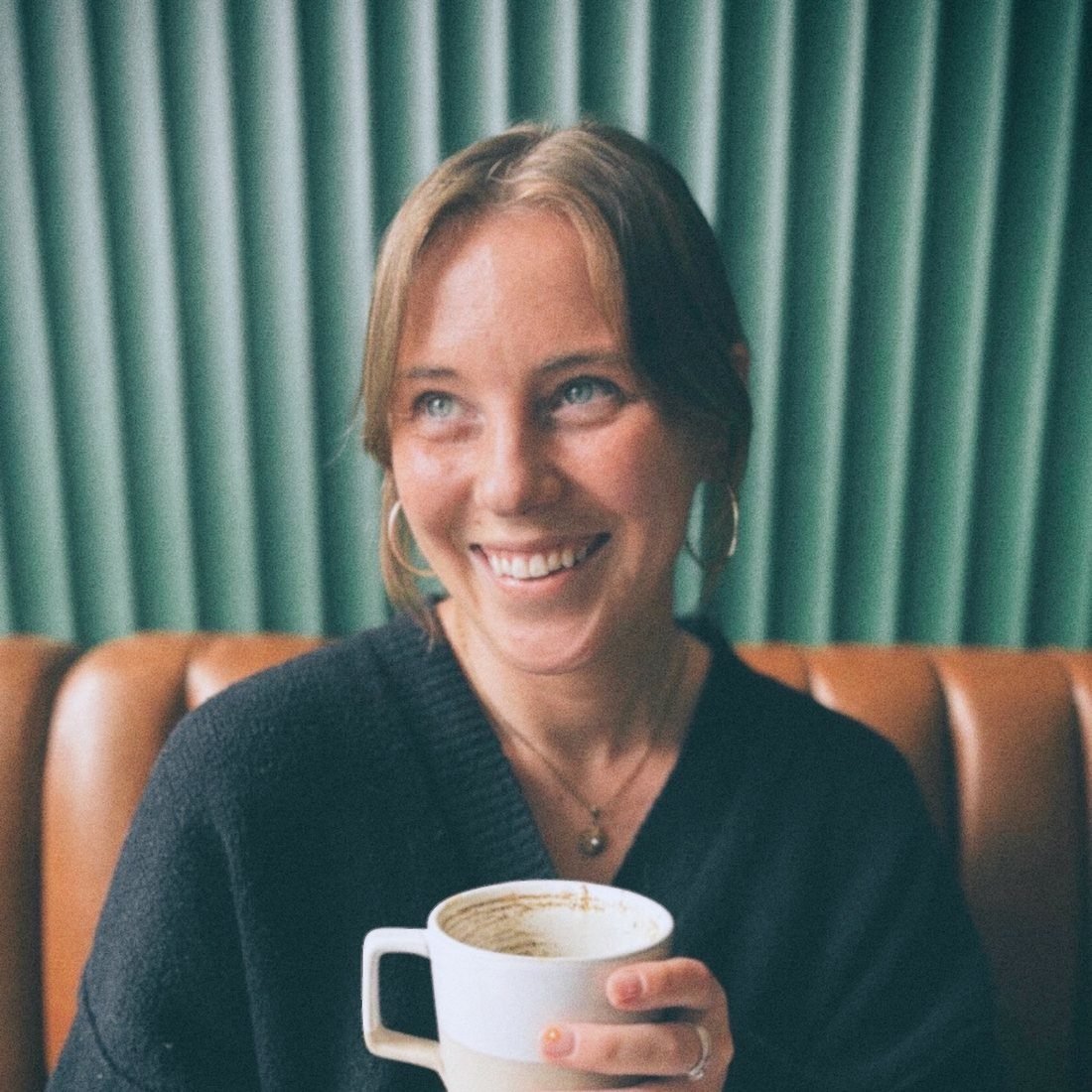 Anna Maddelein smiling, holding a mug