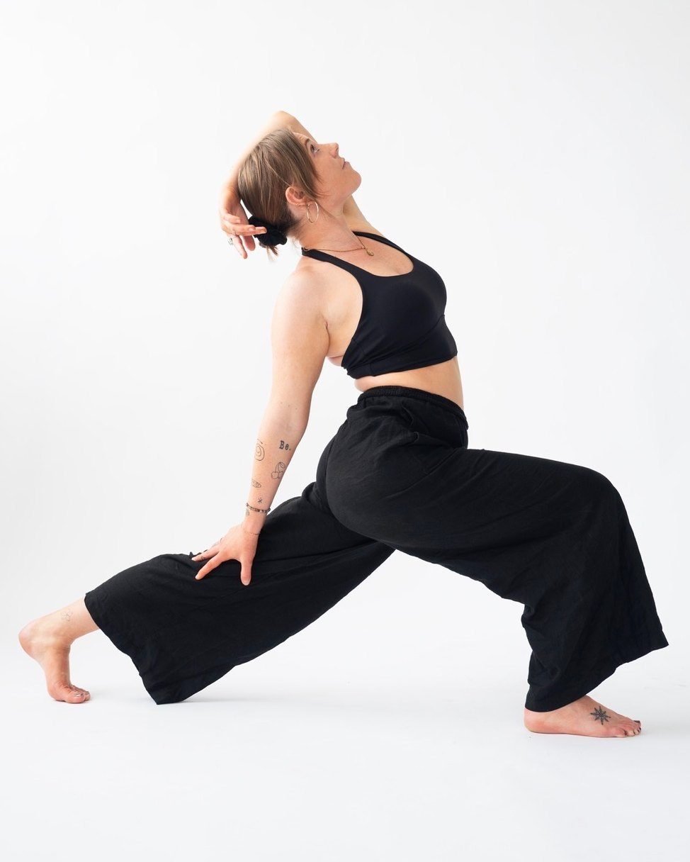 Anna in a low lunge with a gentle backbend, one hand resting on her front thigh